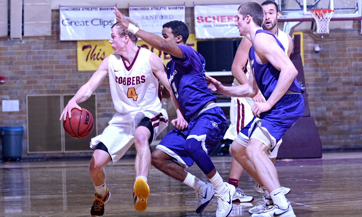 Senior Tom Fraase tries to dribble away from the St. Thomas defense in the Cobbers nine-point loss to the No.5-ranked Tommies.