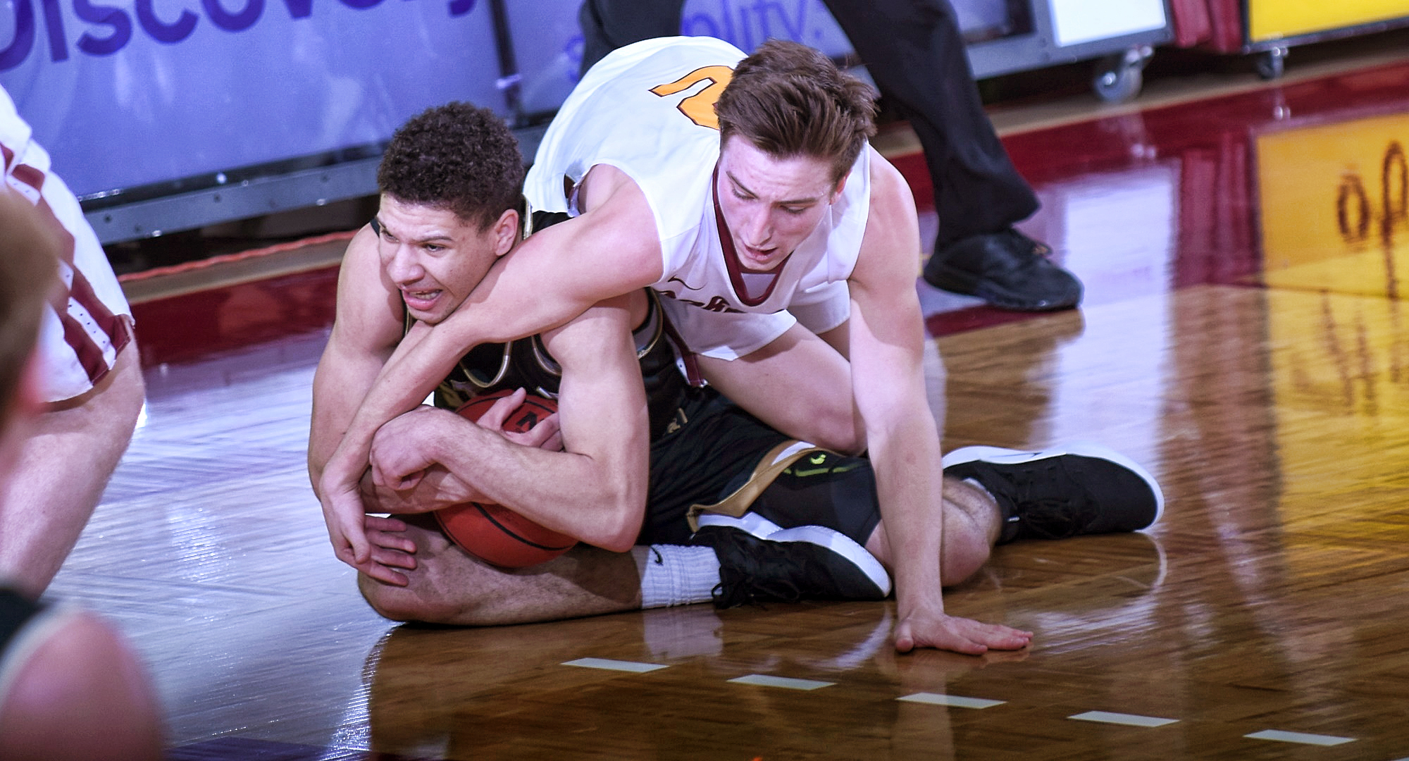 Sophomore Bryden Urie dives on the floor for a loose ball during the second half of the Cobbers' game with St. Olaf.