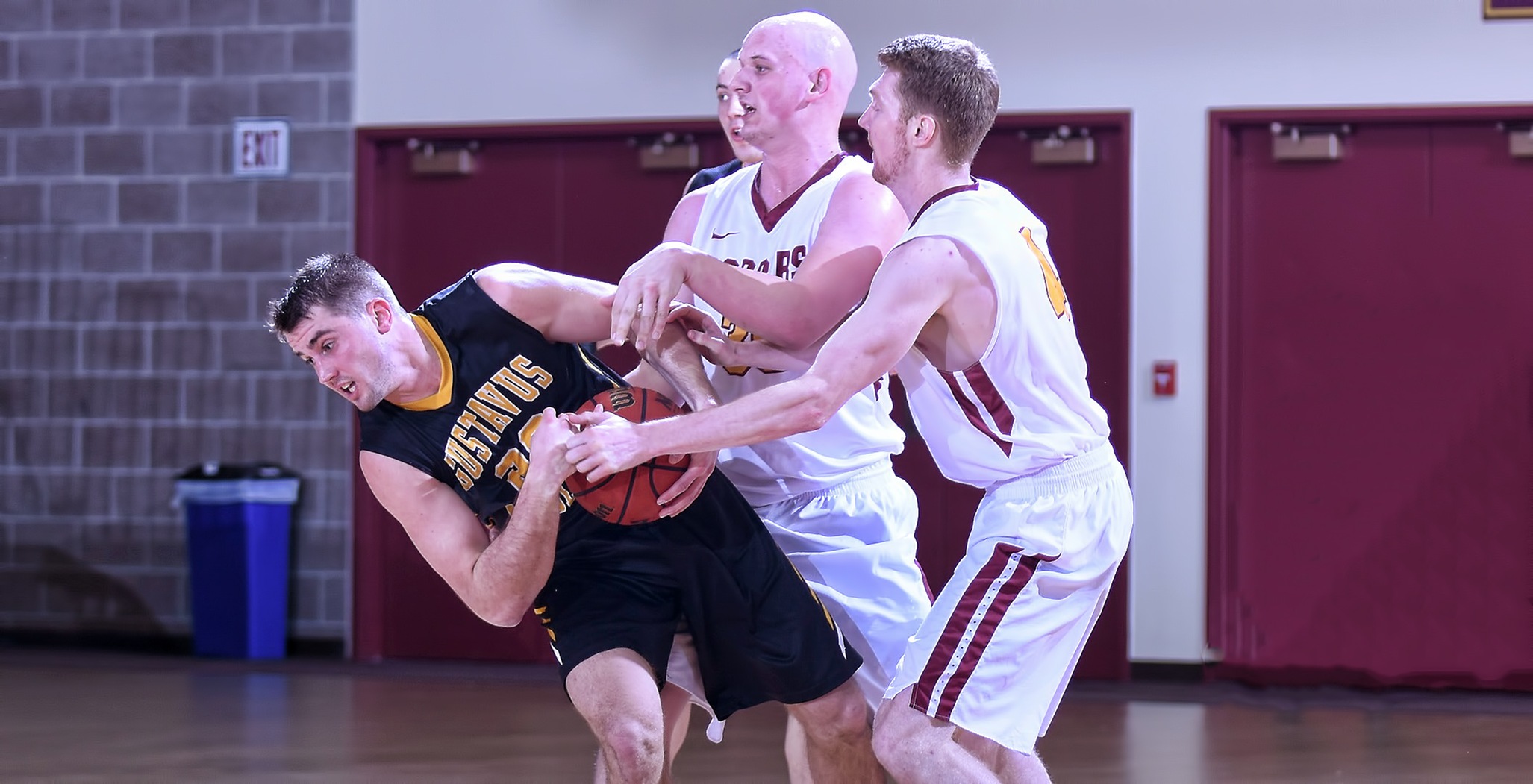 Seniors Dawson Peterson (L) and Collin Larson fight for a loose ball in the second half of the Cobbers' season finale with Gustavus. Peterson finished with a career-high 14 points.