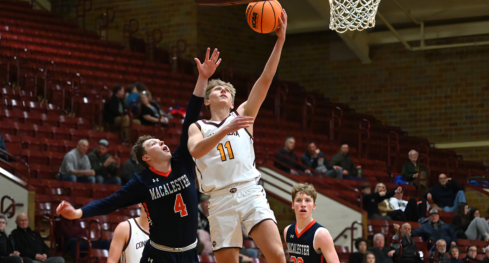 Peyton Belka goes past a Macalester defender to lay in two of his 14 points in the Cobbers' game with the Scots.