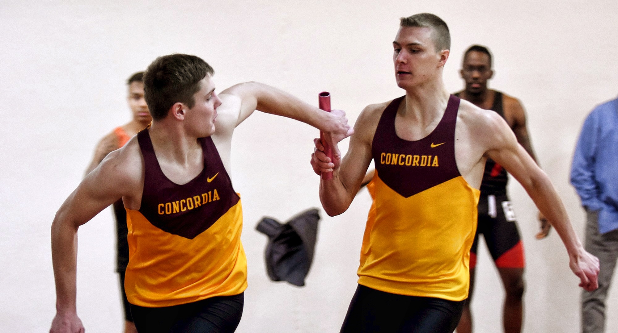 Freshman Cal Wright hands the baton to fellow first-year athlete Hayden Gagnon during the winning 4x200-meter relay race.