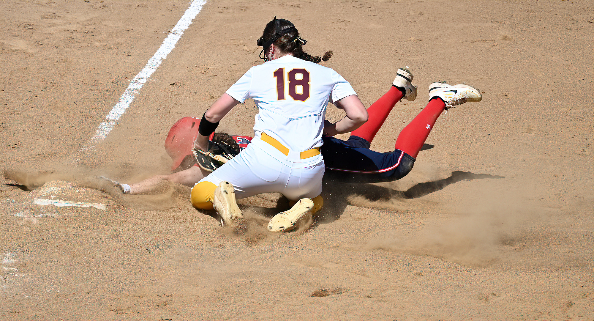 Sophomore Kate Gulbranson applies the tag to a St. Mary's runner for an out at third base in Game 1 of the Cobbers' DH with St. Mary's.