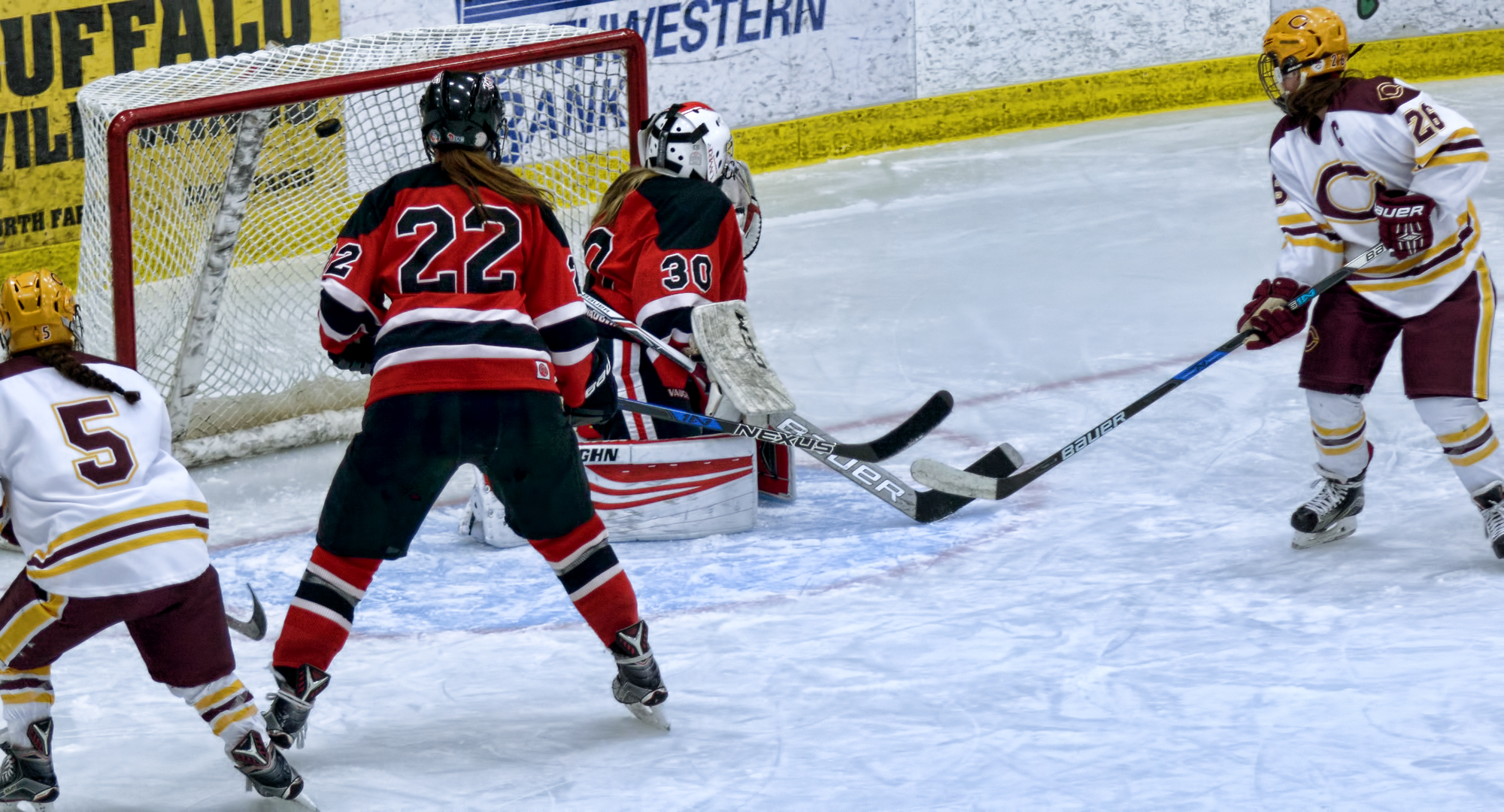 Tori Davis (#26) and Josee Lundgren (5) watch the puck fly into the net after teammate Callie Fagerstrom's shot in the third period against #6 Wis.-River Falls.