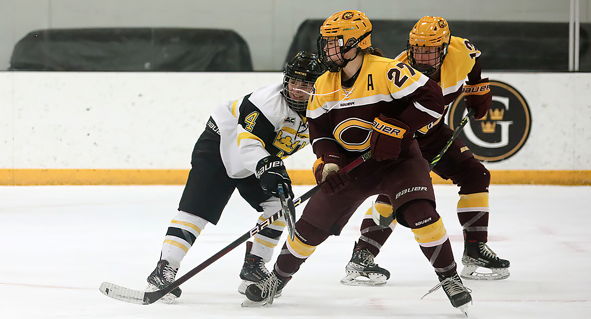 Senior Grace Doerring battles a Gustavus player for the puck during the first game of the series. (Photo courtesy of Gustavus Sports Info)