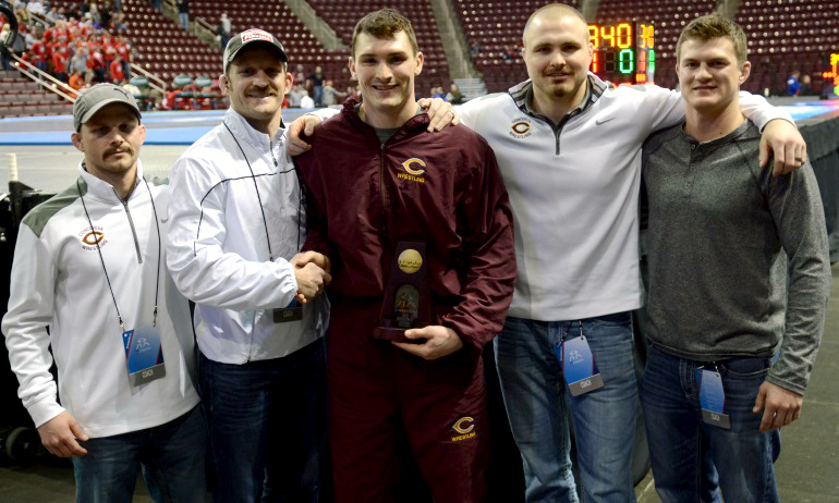 Sebastian Gardner poses with the Cobber coaching staff after receiving his All-American honor for finishing sixth at the NCAA Meet.