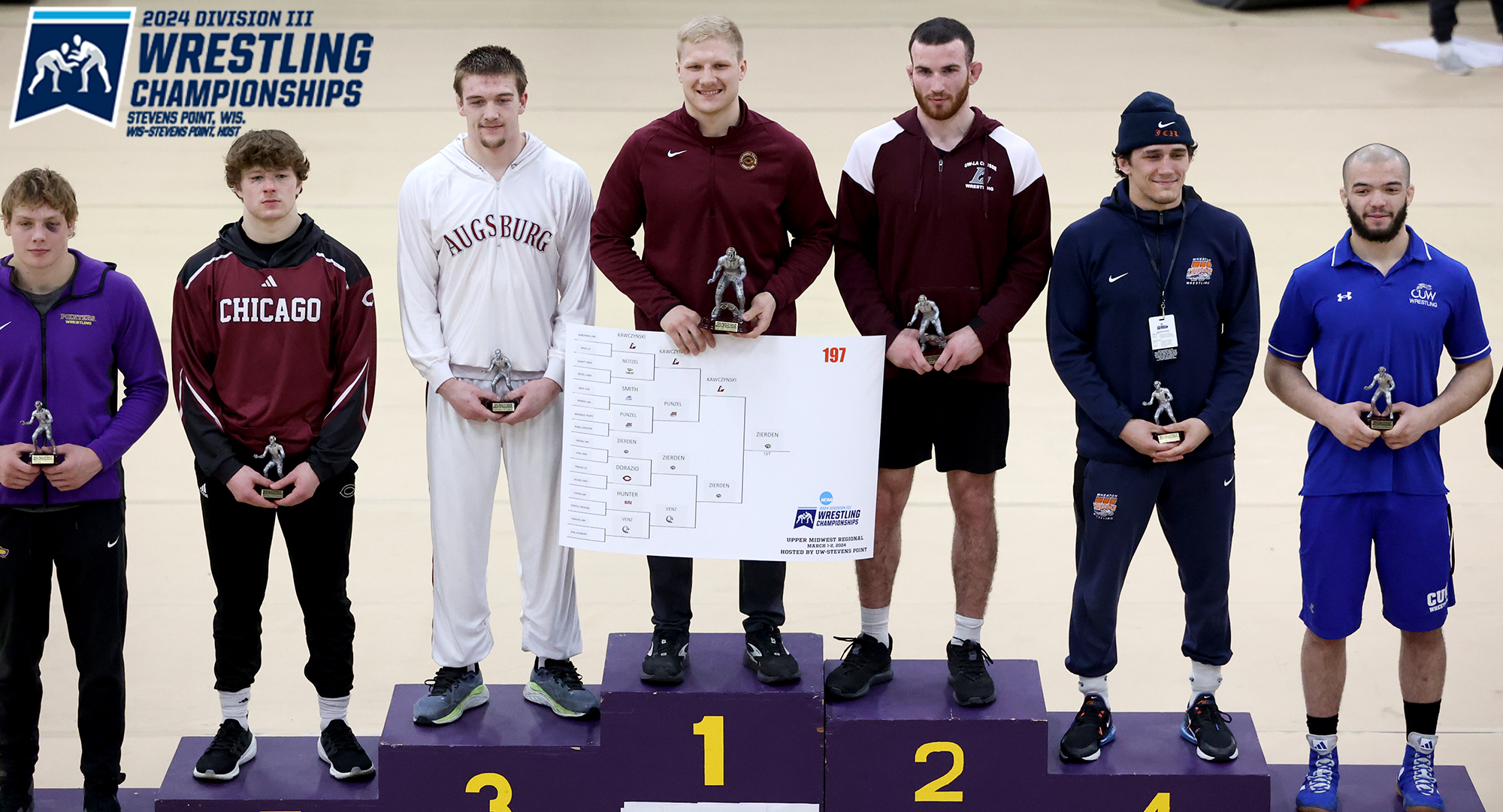 Gabe Zierden poses on the podium with the bracket and the first-place trophy after winning the 197-lb weight class. (Photo courtesy of UWSP SID)