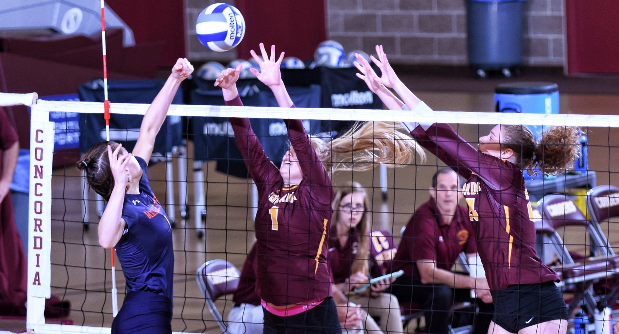 Bailey Gronner (L) and Kendra Wiggs go for the block during the Cobbers' sweep over Macalester.
