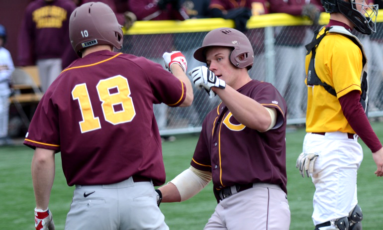 Aaron Green (R) is congratulated by Devin Johnson after Green scored one of the Cobbers' 23 runs vs. Minn.-Morris.