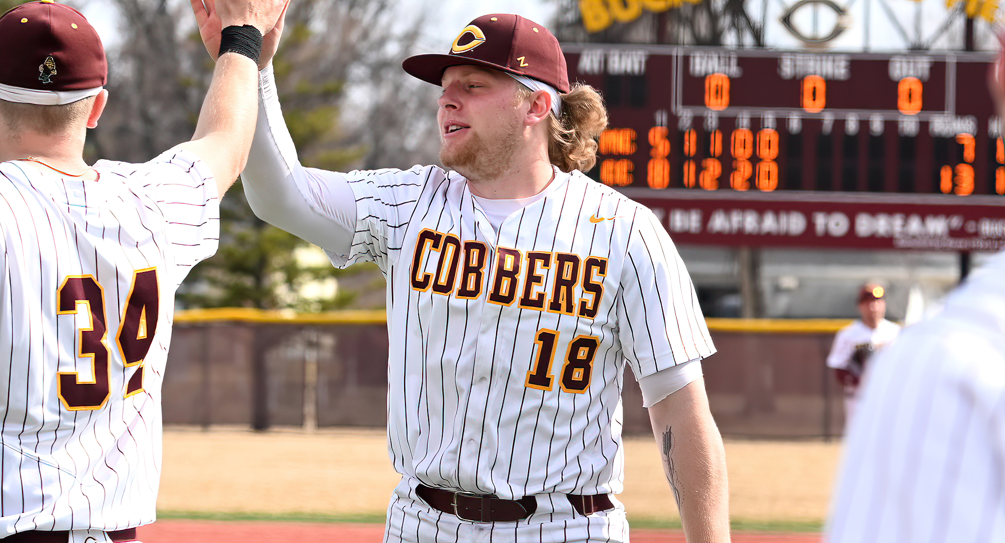 Isaac Henkemeyer-Howe gives out high-fives during the Cobbers' sweep over Macalester. He went 6-for-8 with 8 RBI and a homer in the series.