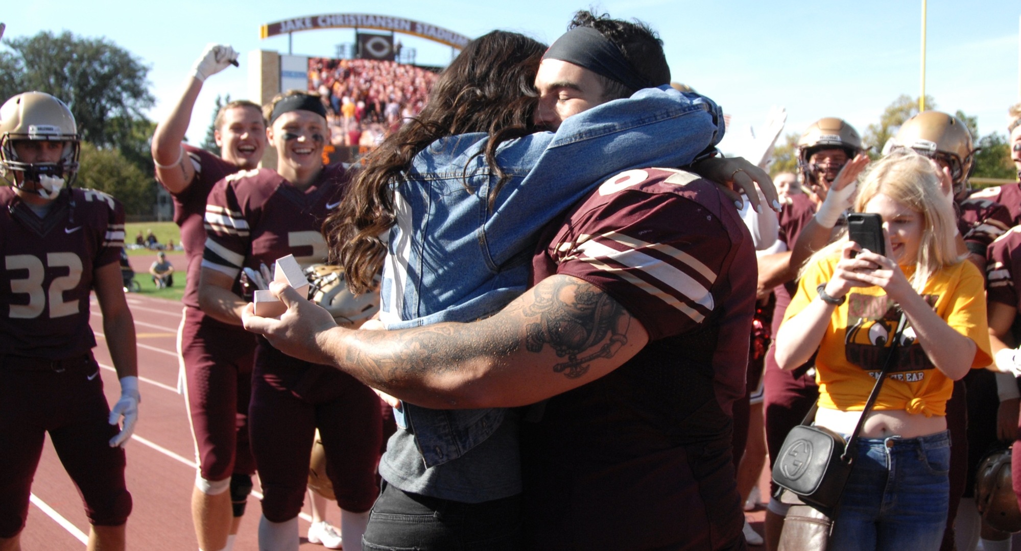 Senior Gunnar Kollman and fiance Addy Johnson hug after Kollman proposed to her after the Cobbers' win over Hamline.