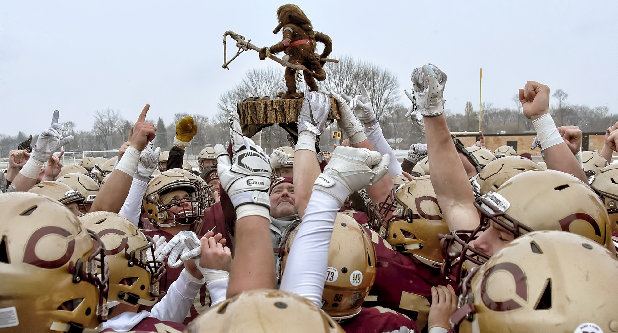 Cobber head coach Terry Horan hoists the Troll Trophy after Concordia blanked St. Olaf 14-0 in the 46th annual Lefse Bowl.