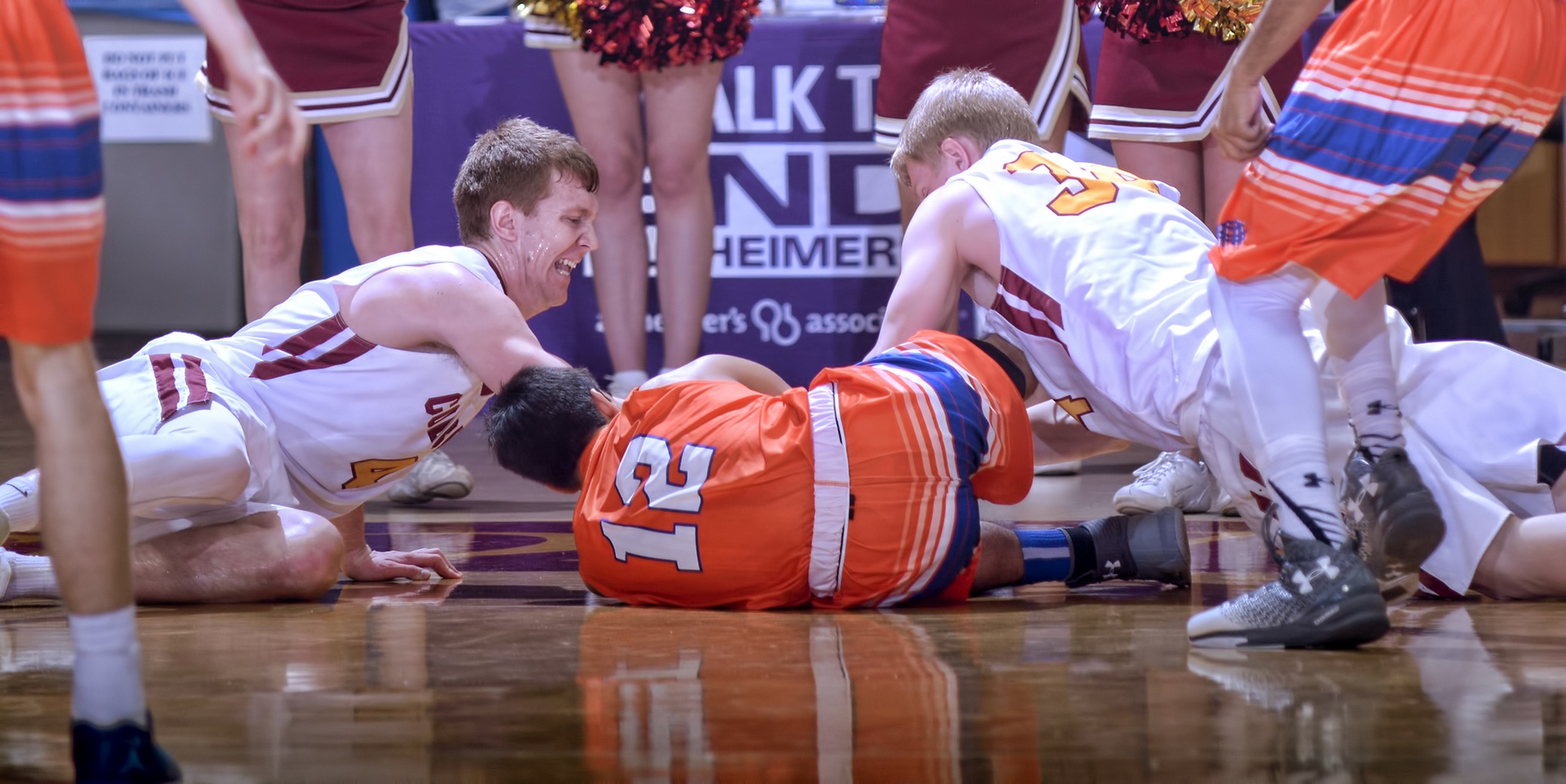 Collin Larson (L) and Andrew Hoeln dive on the floor for a loose ball during the Cobbers 100-81 win over Macalester.