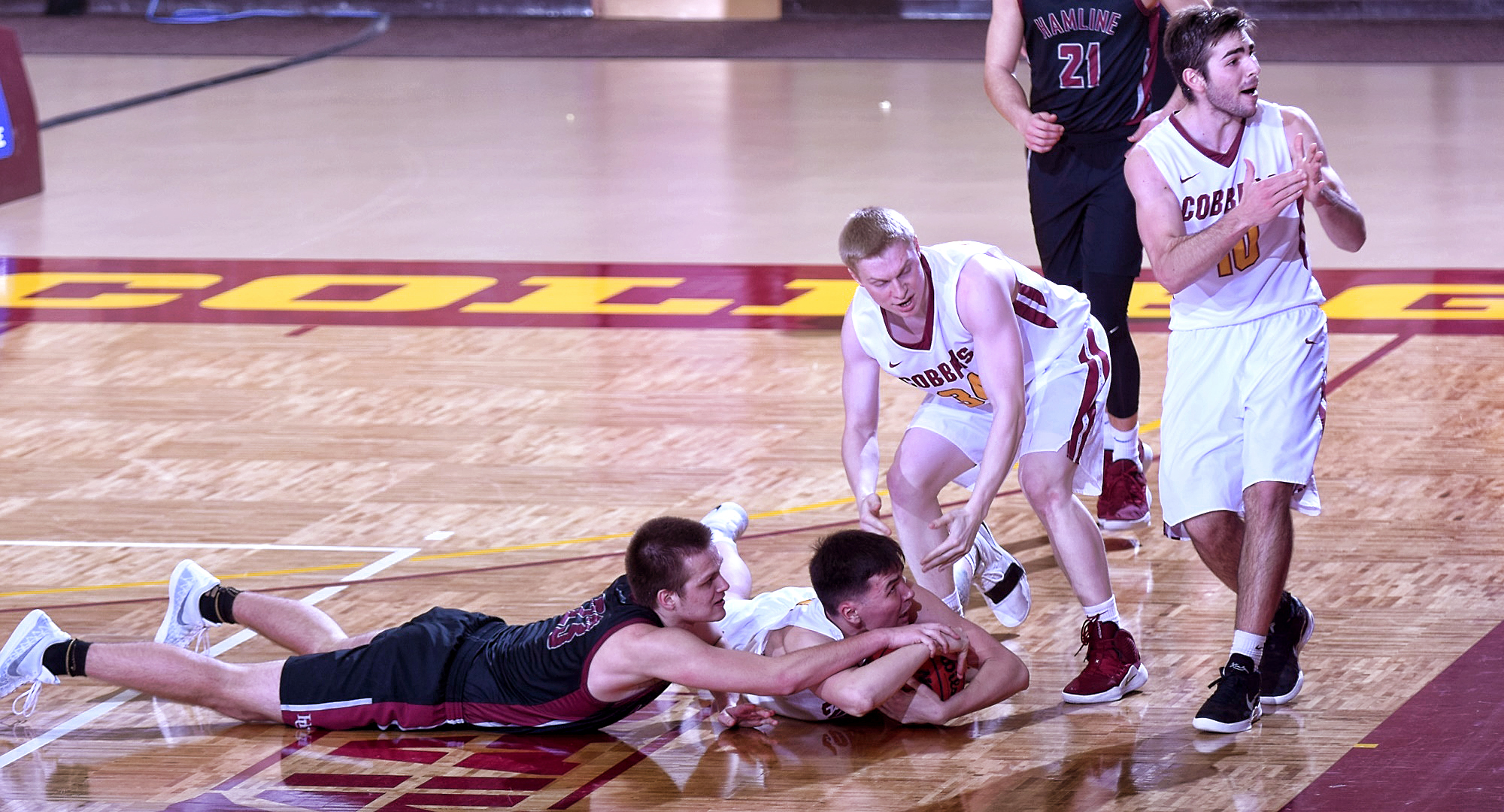 Senior Jordan Davis dives on the floor to grab the ball as teammate Tommy Schyma calls for timeout late in the second half of the Cobbers' 68-62 win over Hamline.
