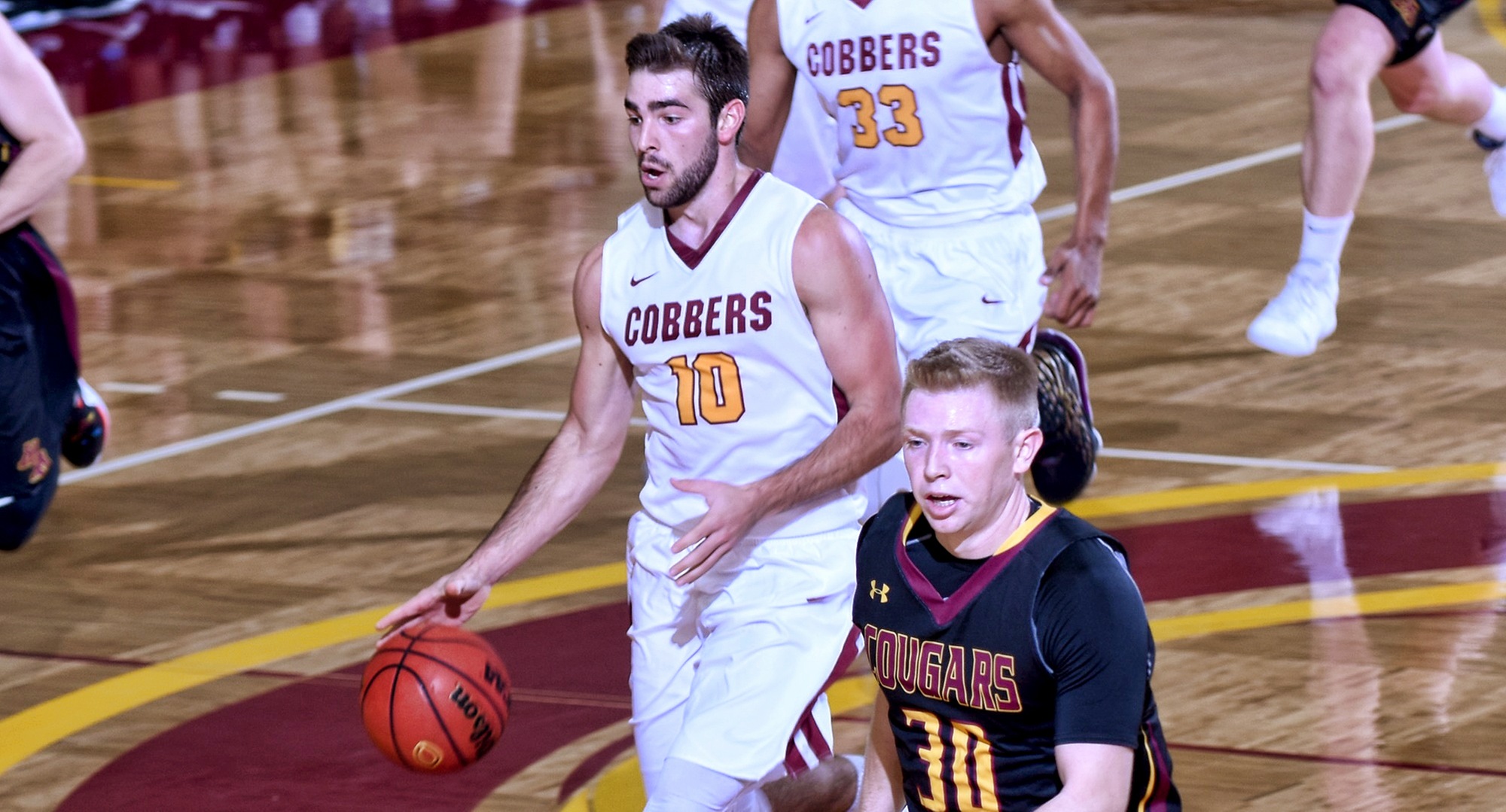 Senior Tommy Schyma dribbles the ball up the court on the fast break during the Cobbers' season opener with Minn.-Morris. He led all players with 27 points.