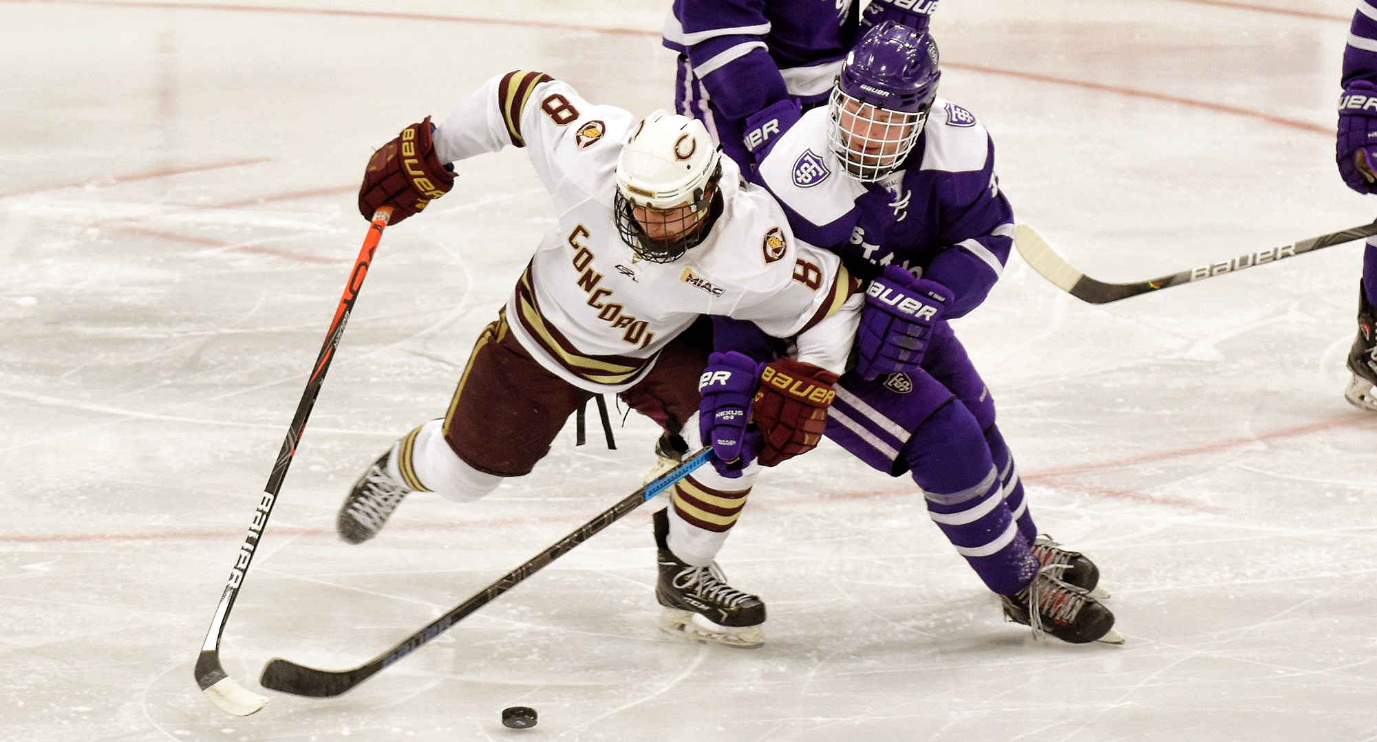 Aaron Herdt gets tied up with a St. Thomas defensive player in the second period of the Cobbers' series finale with UST. Herdt had one of Concordia's two goals on the day.
