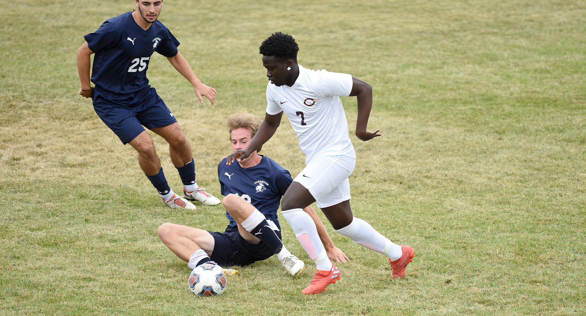 Cobber sophomore Tamba Ngolloe takes the ball away from a Carleton defender during the second half of CC's game with the Knights.
