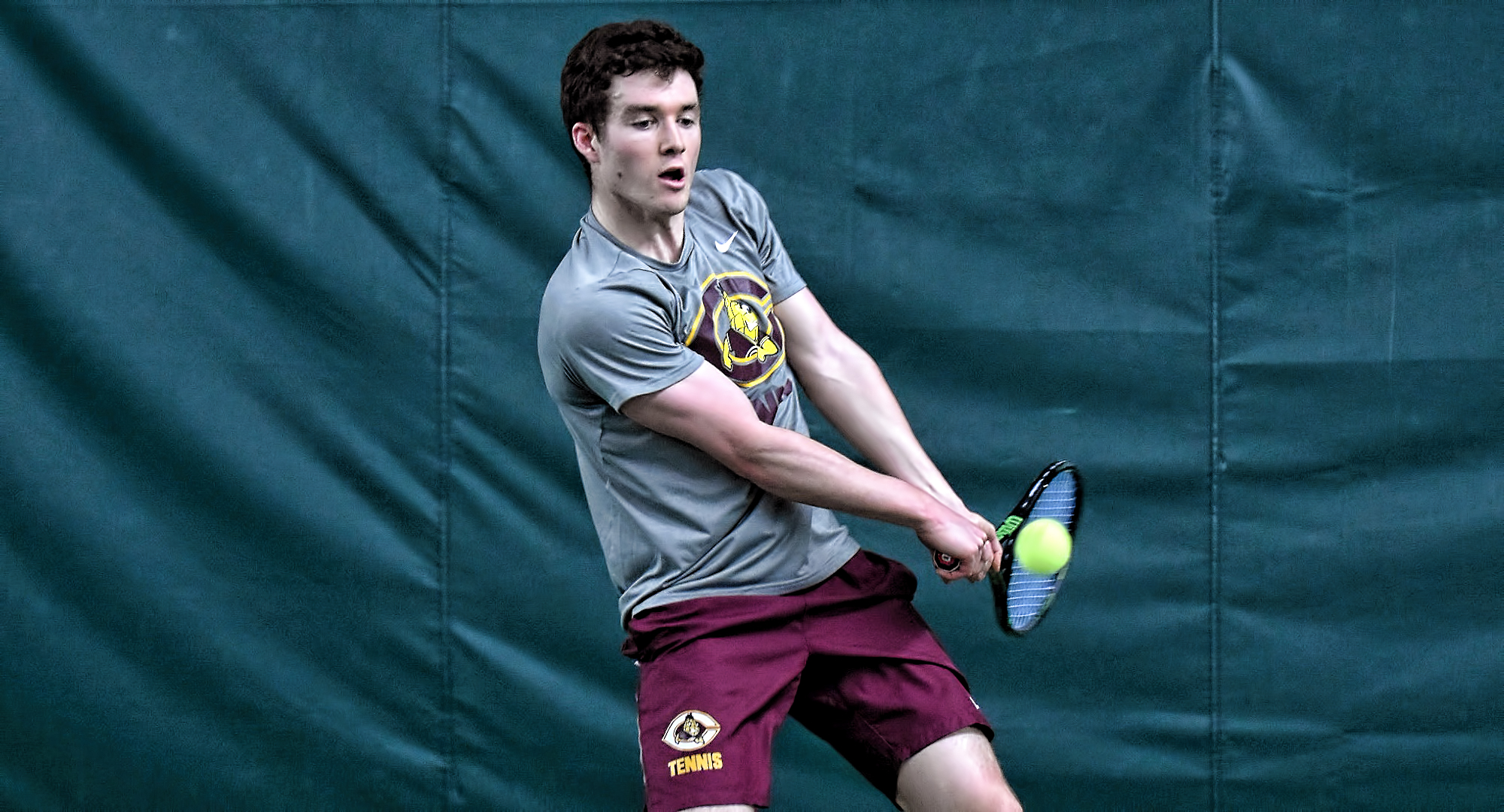 Junior Erik Porter eyes a backhand during his match at No.1 singles against St. Scholastica.