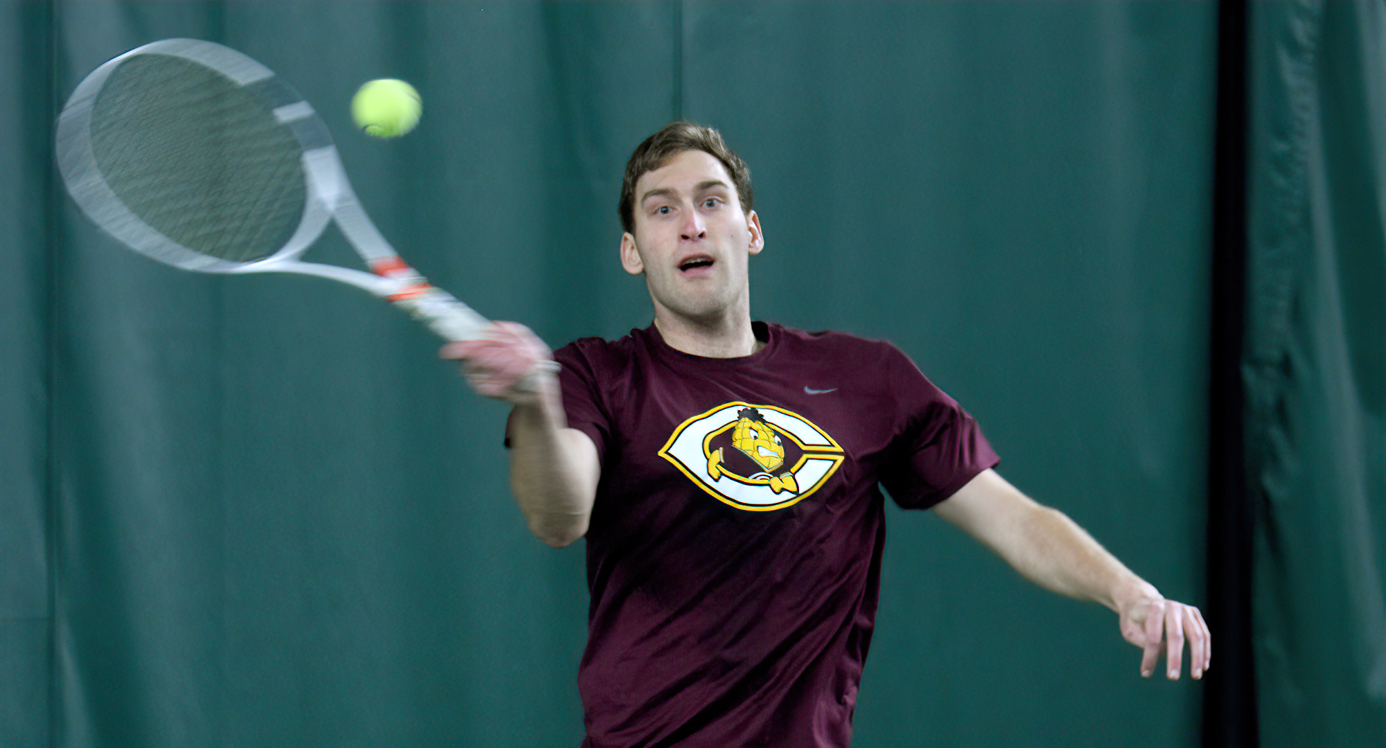 Senior Jake Peters eyes his forehand service return during his singles match in the season opener against Macalester.