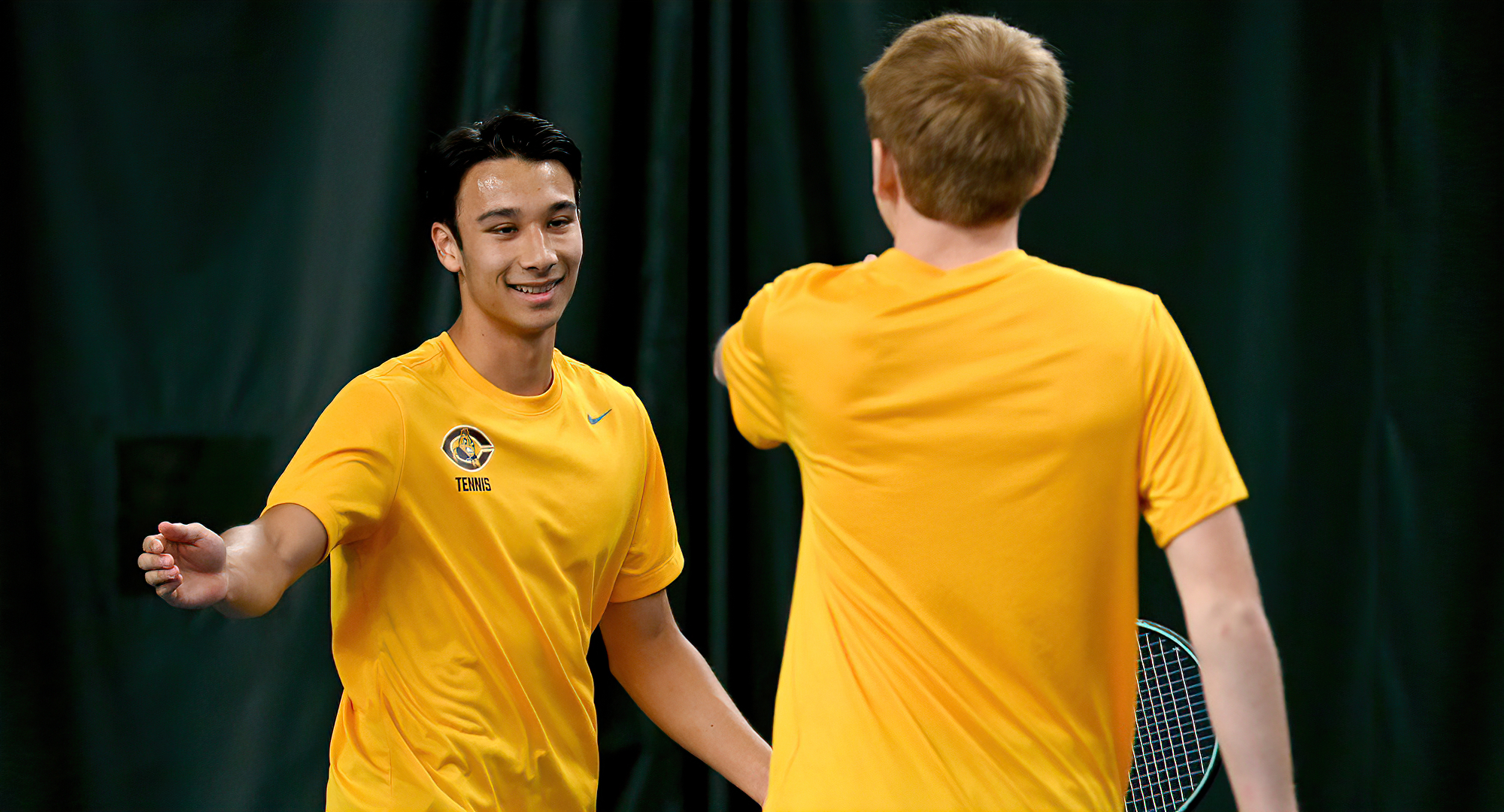 The doubles team of Kai Pierce (L) and Isaac Maddock celebrate winning a point against Macalester. They won both their matches over the weekend.