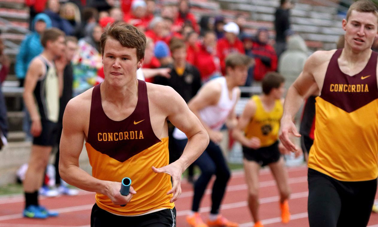 Nick Solheim takes the hand off from David Supinski to start the third leg of the Cobbers' runner-up 4x800-meter relay finish. (Photo courtesy of St. Benedict Sports Information)