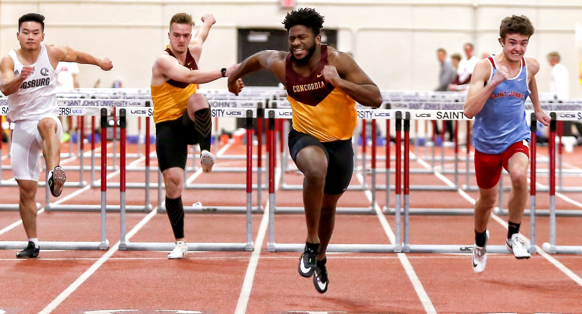 Willie Julkes stretches for the finish line in the prelims of the 60-meter hurdles at the MIAC Indoor Meet. He went on to set a school record in the finals of the event. (Photo courtesy of Nathan Lodermeier)