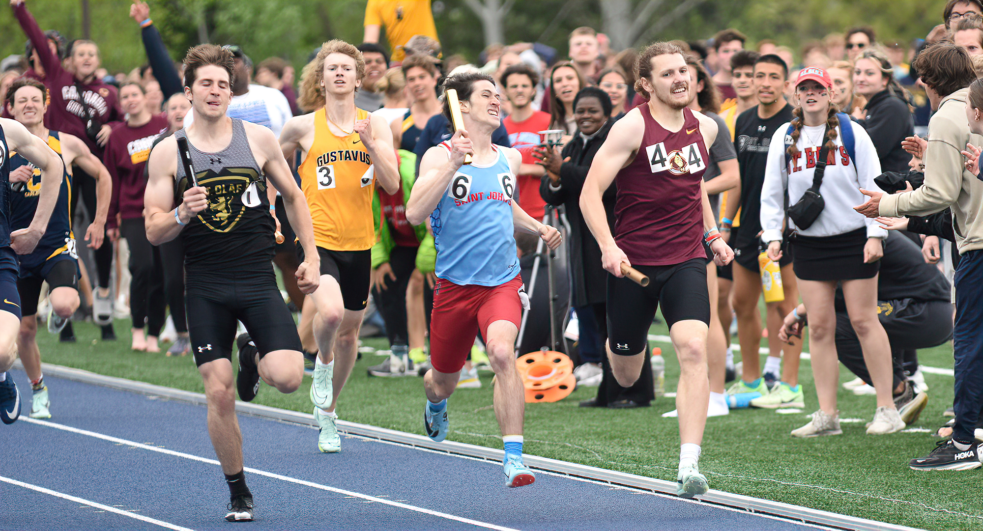 Hayden Gagnon (R) passes runners from Gustavus, St. John's and St. Olaf down the stretch of the 4x400-meter relay at the MIAC Meet.