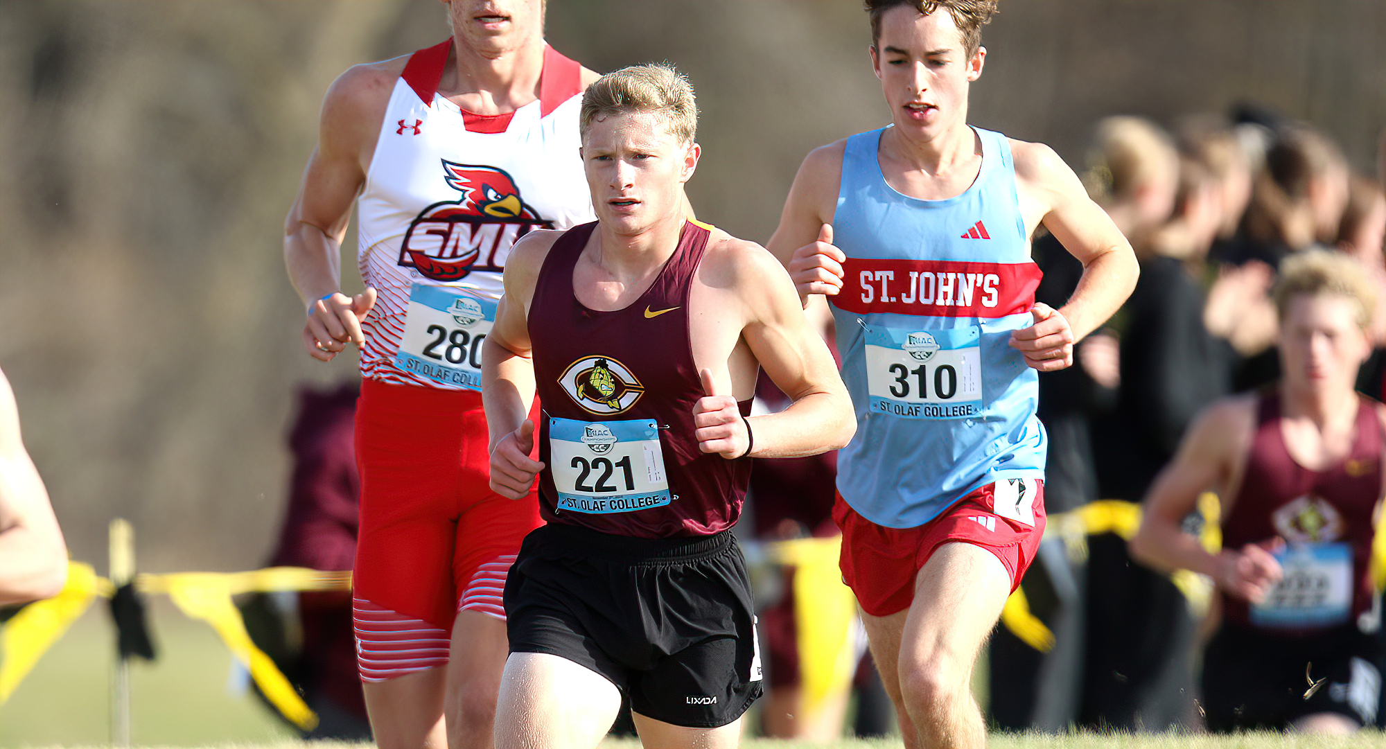 Brady Goss strides past a pair of runners at the MIAC Meet. He earned All-MIAC Honorable Mention honors. (photo courtesy of St. Olaf SID)