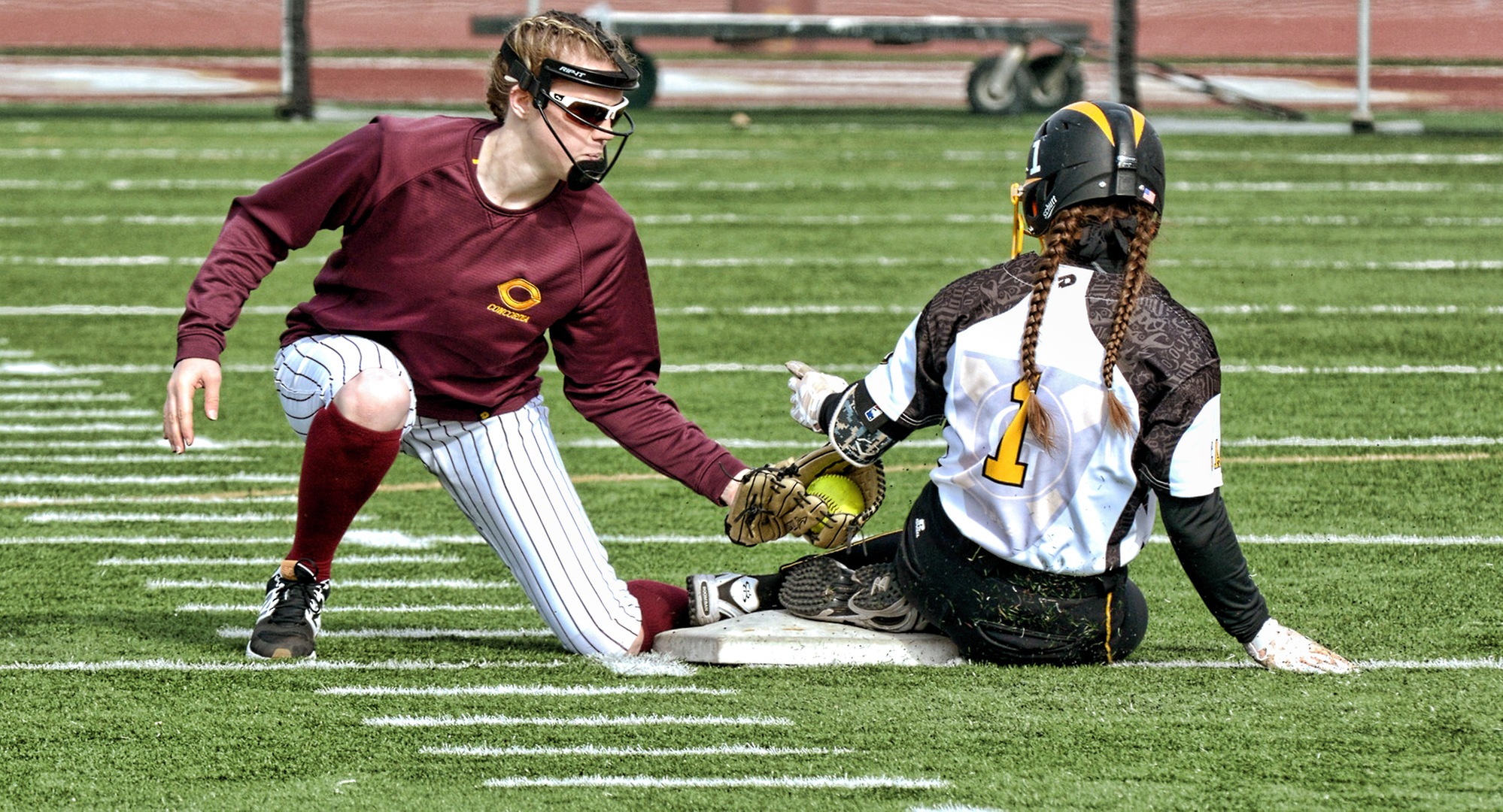 Cobber shortstop Megan Gavin puts the tag on a Gustavus base runner as she steals second base during the second game of the Cobbers' home opener with the Gusties.