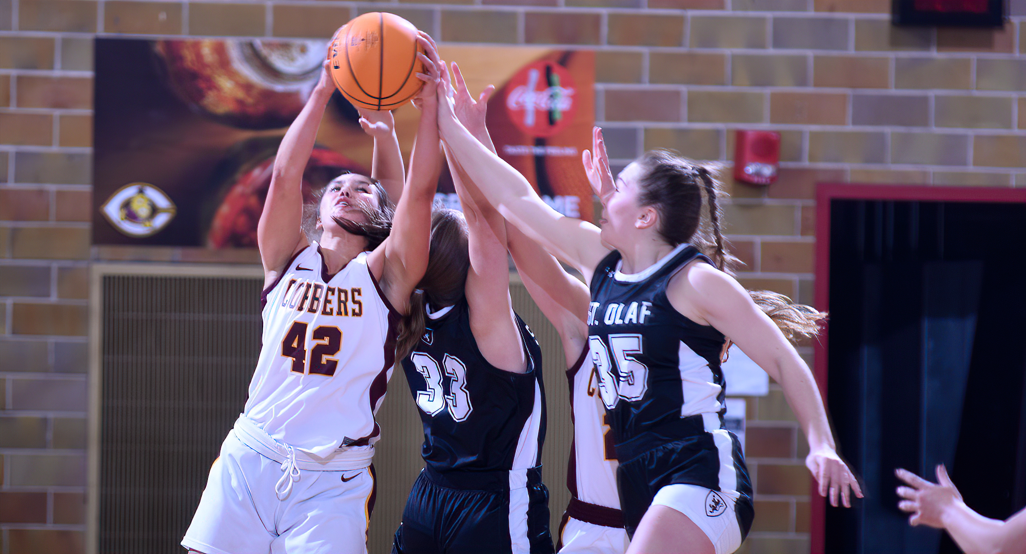 Freshman Makayla Anderson reaches up to grab one of her team-high eight rebounds in the Cobbers' 67-61 win over St. Olaf.