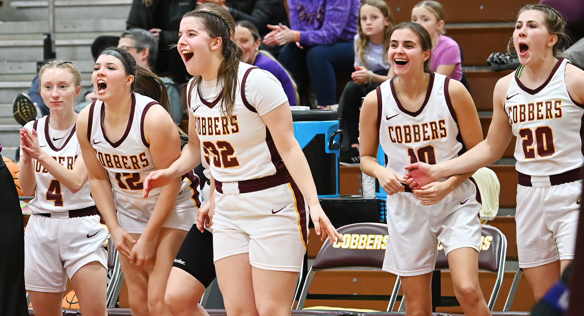 The Cobber bench celebrates Maci Wheeldon's free throw that gave the team 100 points in their conference victory over St. Catherine.