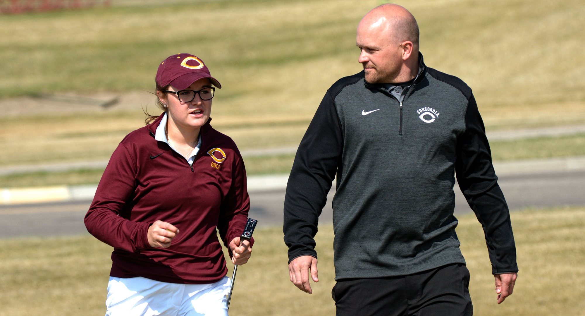 Freshman Katie Krueger talks with head coach Joe Christianson during the first round of the Cobber Open. Krueger placed fifth to earn the first Top 20 finish of her career.