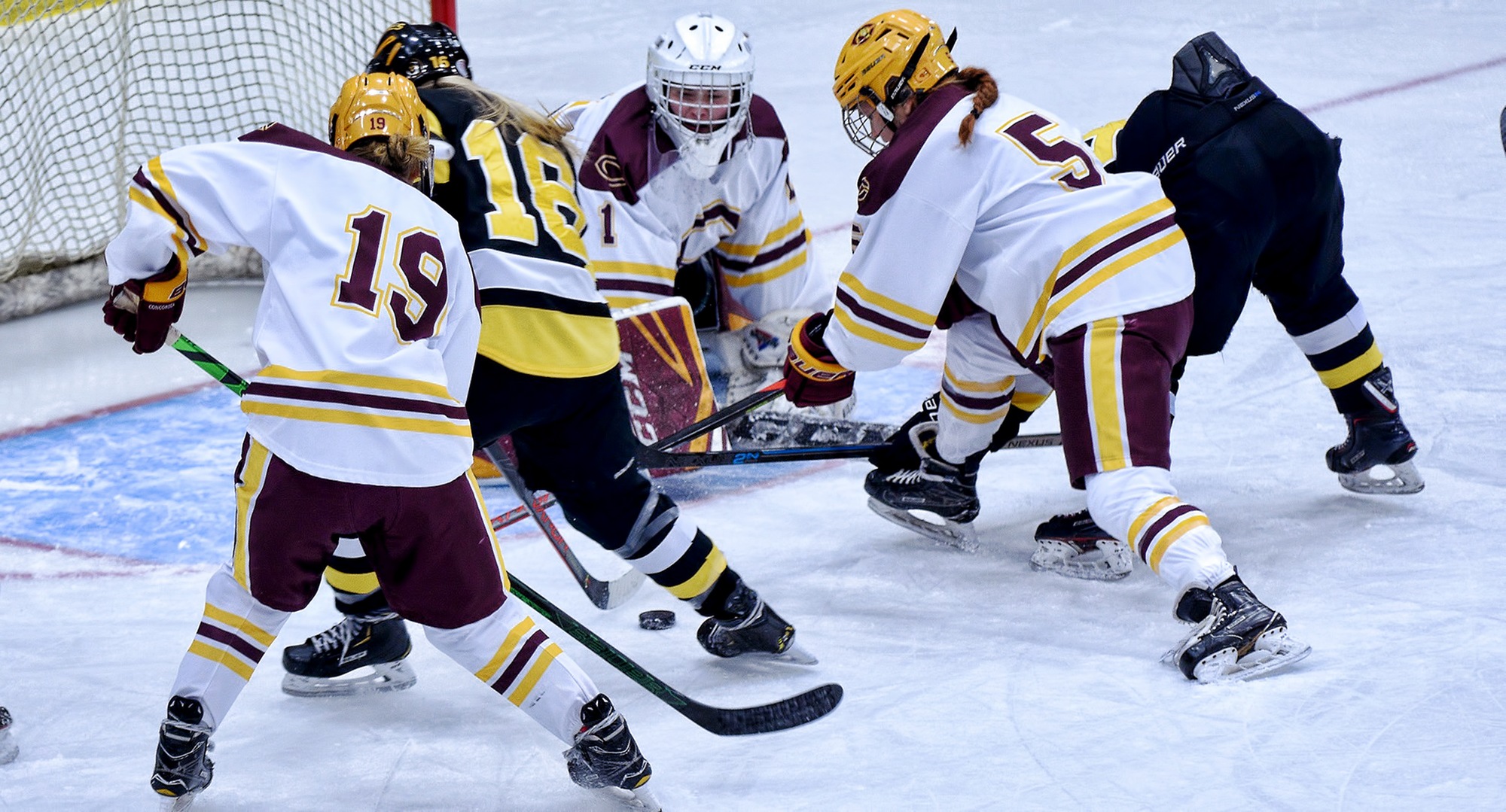 Players scramble for the loose puck after freshman goalie Kiana Flaig made one of her 42 saves in the Cobbers' series opener with Gustavus.