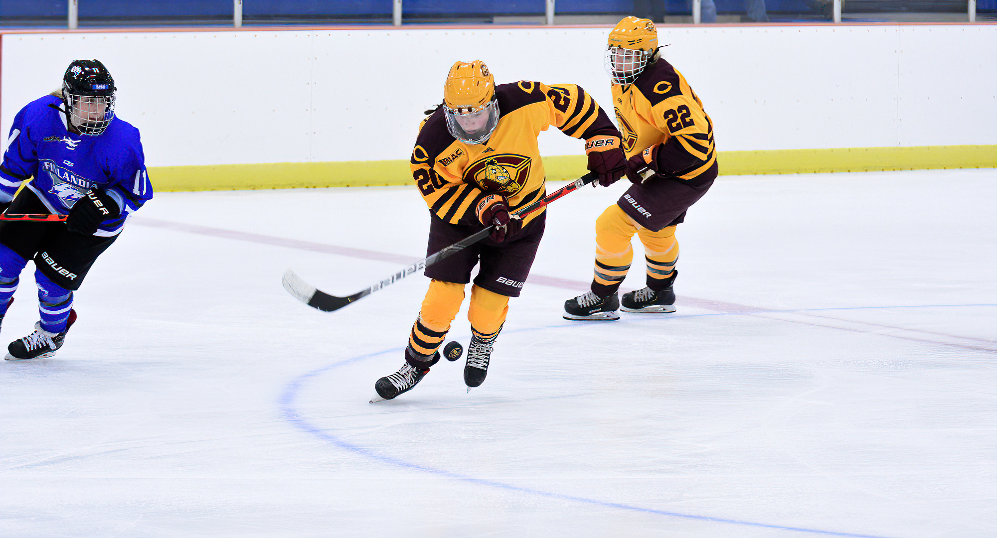Maiah McCowan (#20) settles the puck in the middle of the ice as teammate Libby Hinrichs looks on. The two combined for the game-winning goal against Finlandia.