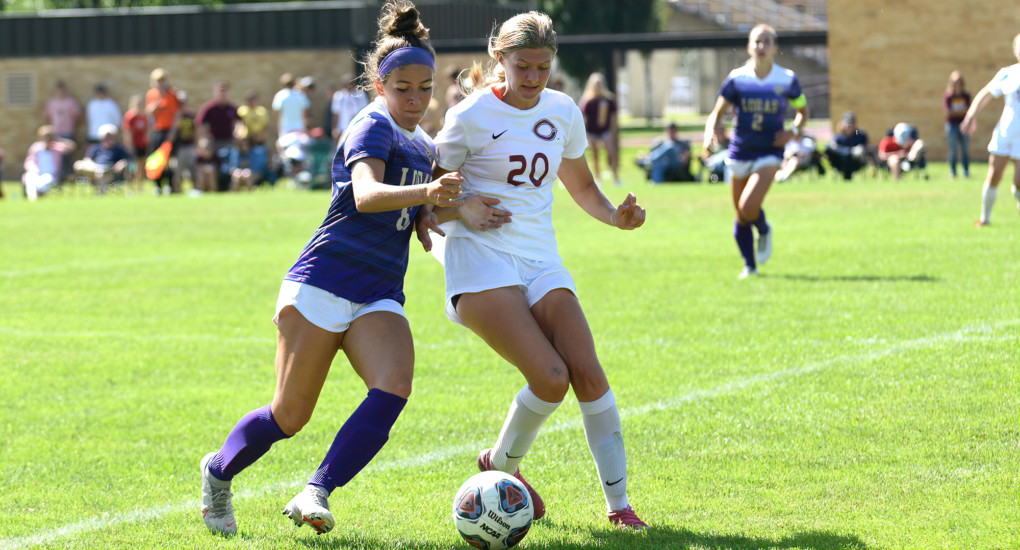 Freshman Hallie Thompson tries to win the ball from a Loras attacker during the Cobbers' game with the Duhawks.