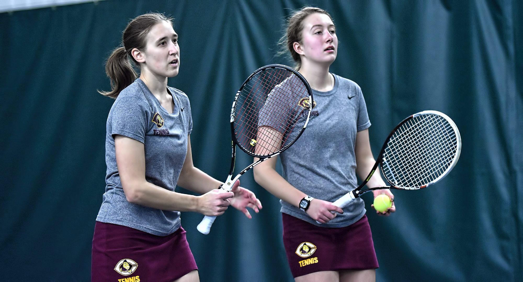The Cobber doubles team of Lisa Neumann (L) and Rachel Saxen react to a point during their 8-6 win at No.3 doubles vs. St. Benedict.