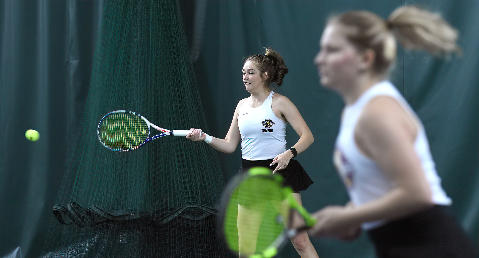 Junior Raquel Egge (L) hits a forehand return as her doubles partner Mark Skorich is in the foreground. The duo went 3-0 over the weekend.