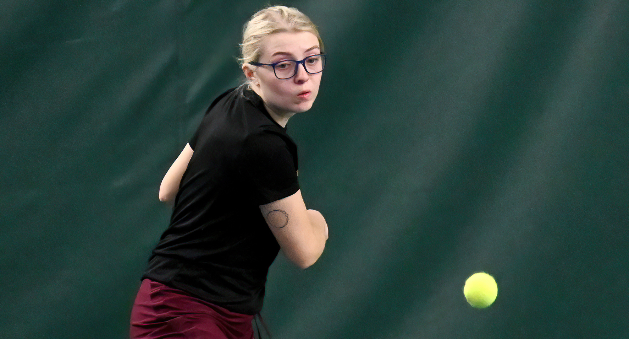 Junior Lizzie Allan eyes the ball as she gets ready to hit a backhand during her match at No.5 singles in the Cobbers meet with MSU Moorhead.