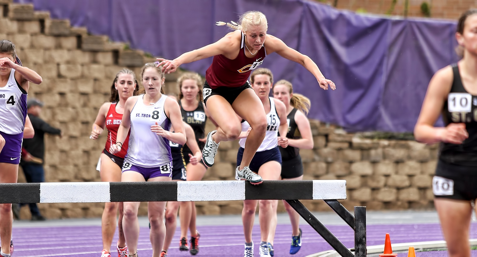 Junior Miriah Forness clears the steeplechase hurdle at the MIAC Meet. She went on to finish fifth in the event with the seventh fastest time in school history. (Photo courtesy of Nathan Lodermeier)