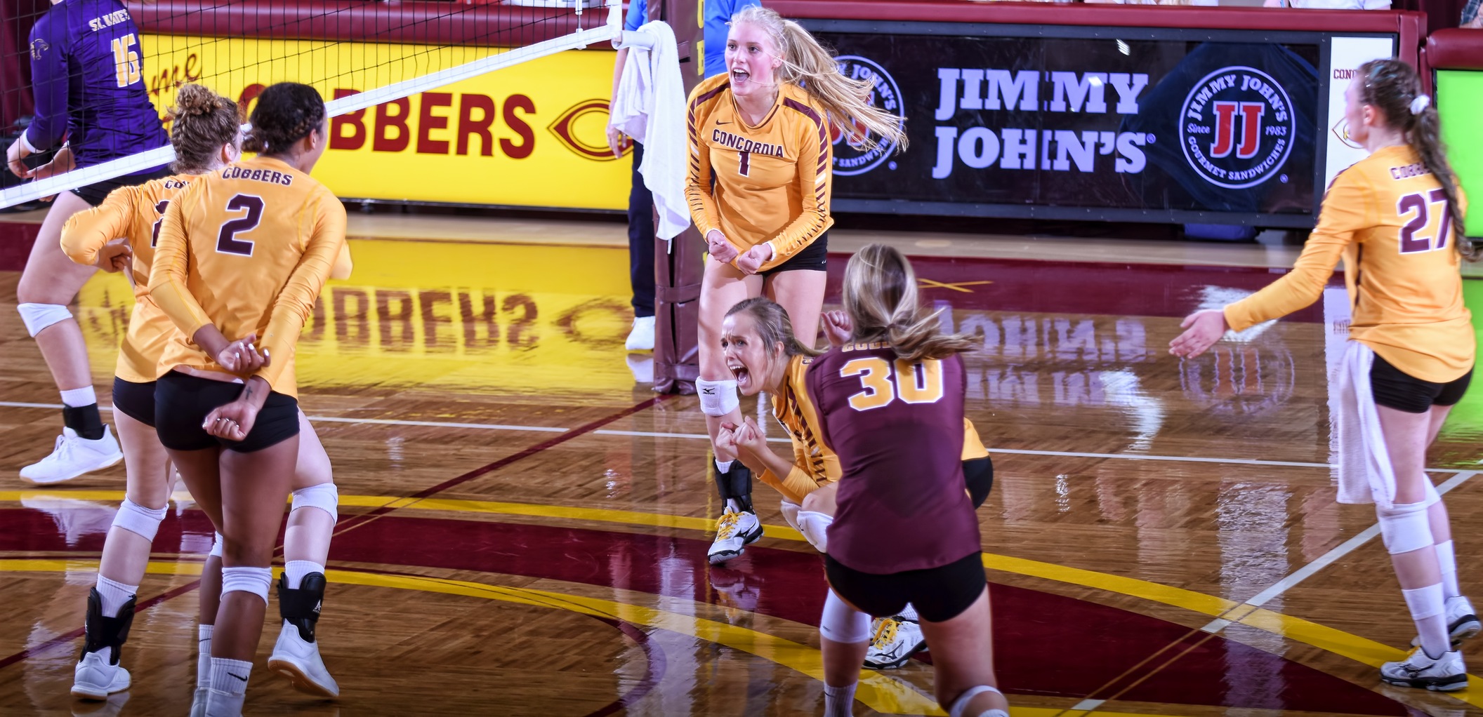 Cobber players celebrate match point in their come-from-behind win over St. Catherine in the home opener.