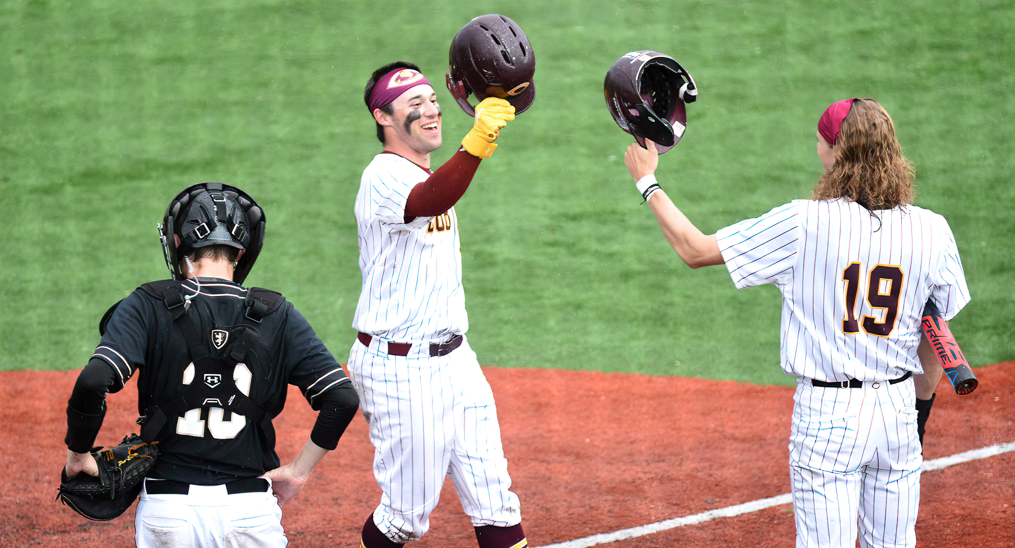 Justin Kloster (L) is congratulated by Max Boran after Kloster cranked out a 2-run home run in the eighth inning of Game 2 against St. Olaf.