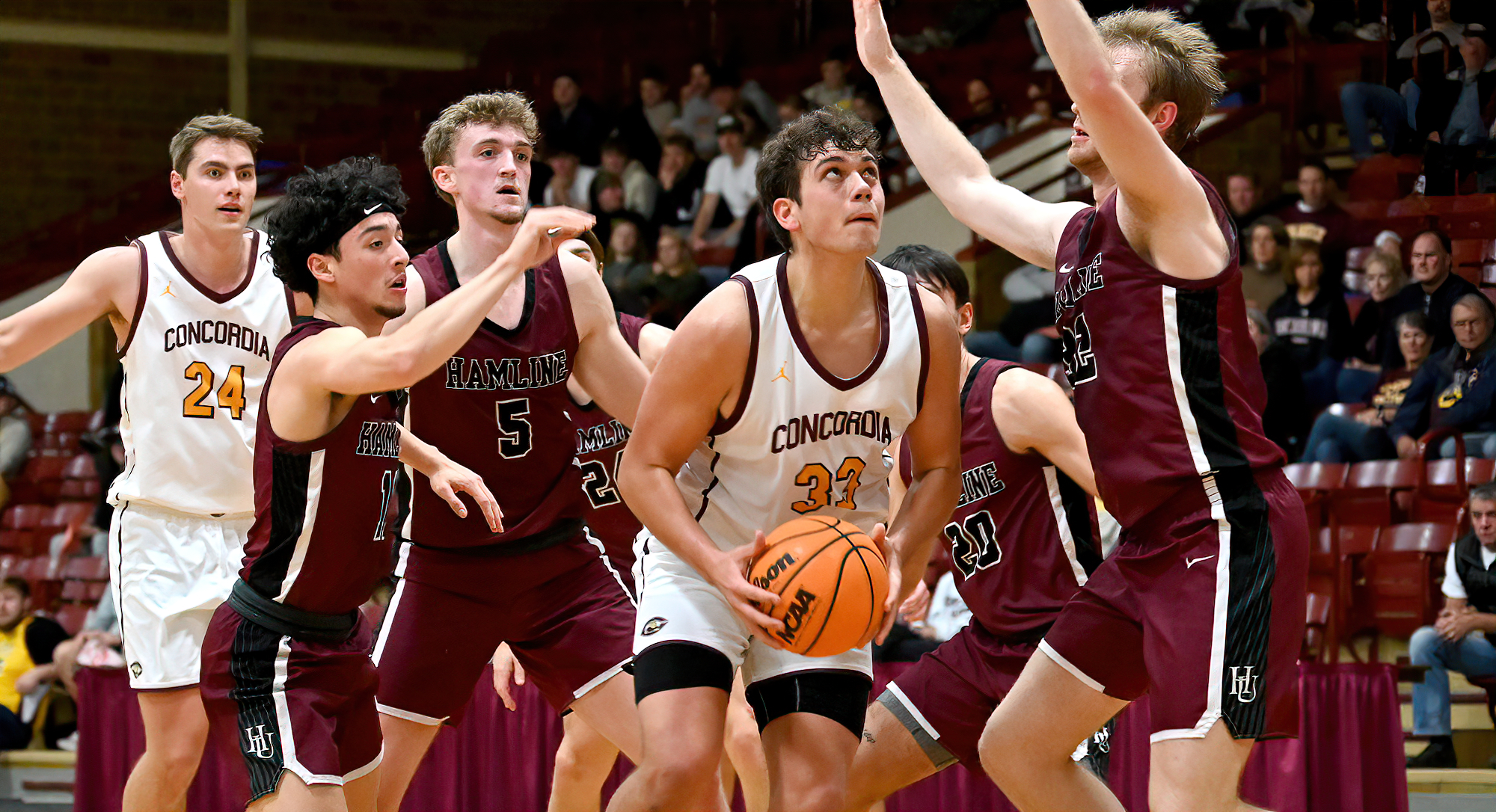 Jacob Cook eyes the basket as he is surrounded by three Hamline defenders in the Cobbers' game with the Pipers.