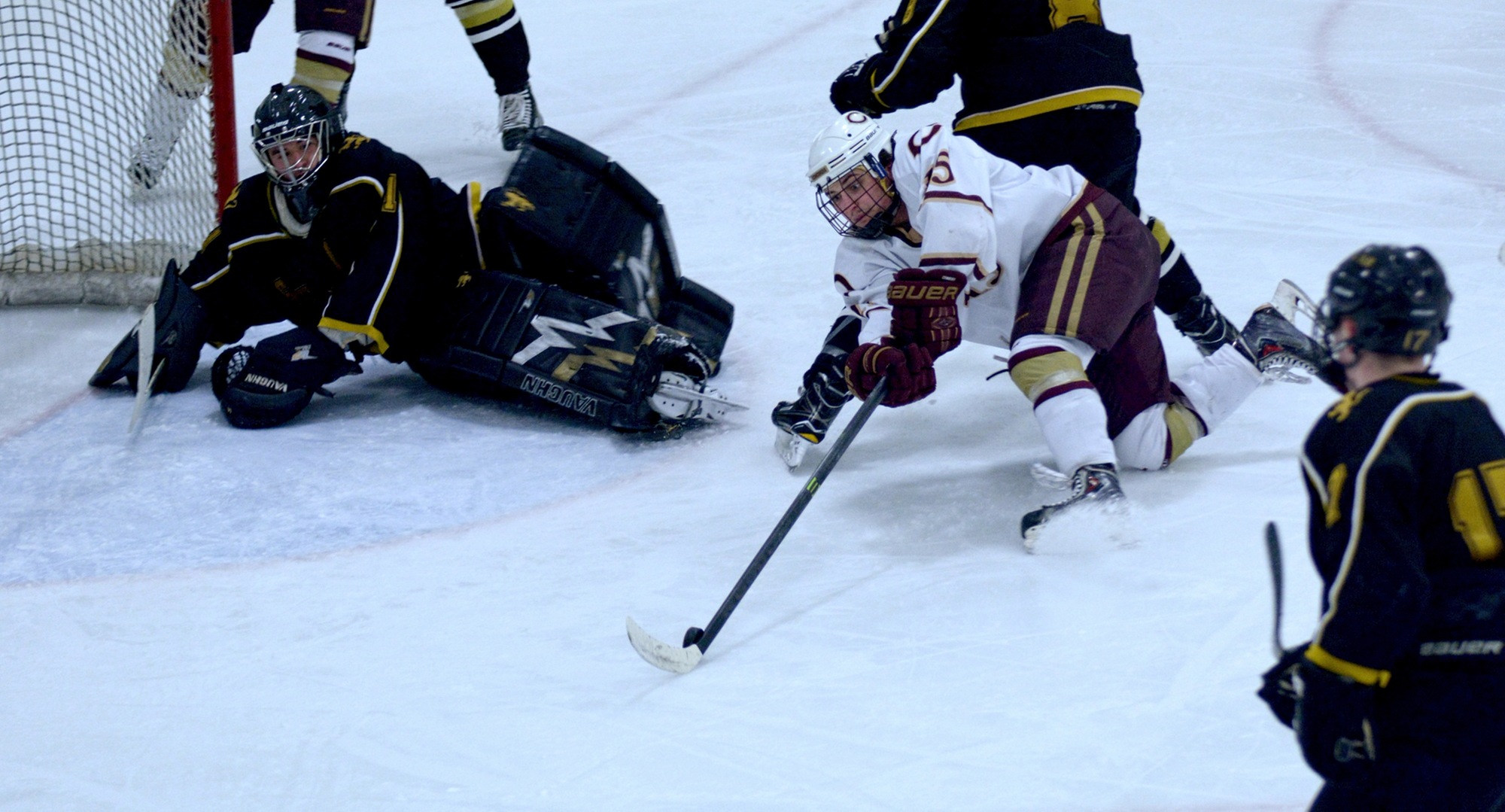 Junior Mario Bianchi reaches for a loose puck right in front of the St. Olaf during the Cobbers' series finale with the Oles.