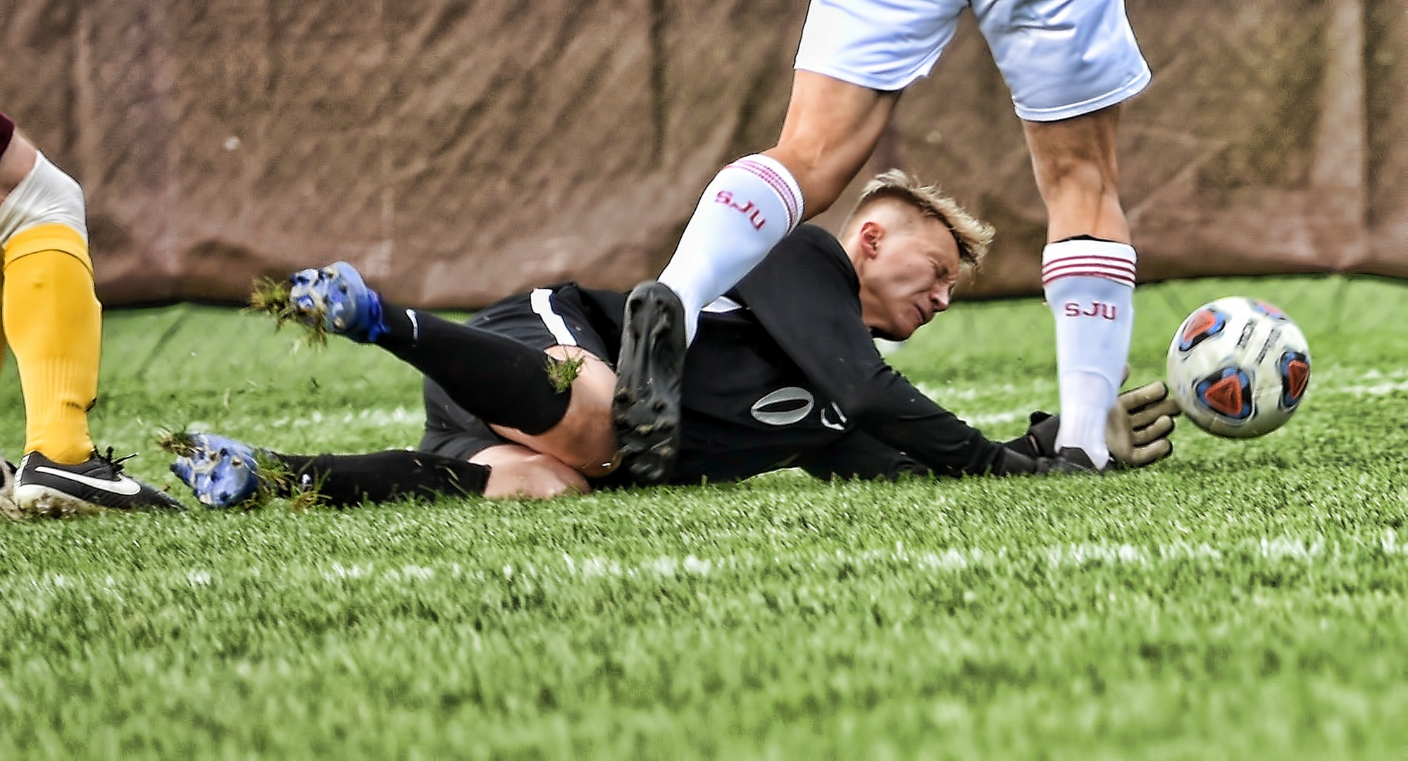 Cobber senior goalie Keith Sullivan makes a diving stop at the feet of a St. John's player. Sullivan stopped a penalty kick in the second half of the MIAC opener.